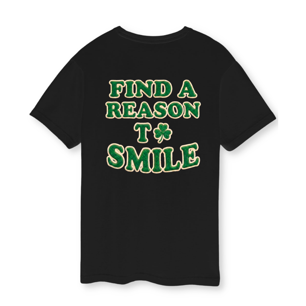 Black t-shirt with St. Patrick's themed text 'Find a reason to smile' on a white background